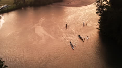 Aerial-of-Rowers-Paddling-through-Bay-during-Sunset