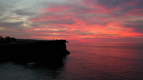 The-beautiful-fiery-red-sunset-view-in-the-horizon-of-Uluwatu-in-Bali,-Indonesia---Aerial-shot