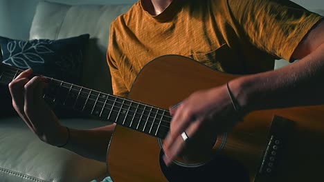 boy strumming guitar on a couch