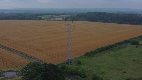 poste de acero eléctrico cables de alta tensión en el campo granja agrícola campo vista aérea temprano en la mañana amplia inclinación hacia abajo empujar