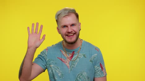 bearded man smiling friendly at camera and waving hands gesturing hello or goodbye, welcoming