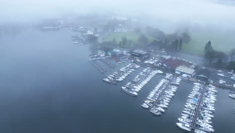 Drone-approaching-a-lakeside-village-know-for-its-boat-building-industry,-located-in-the-county-of-Cumbria-in-Great-Britain