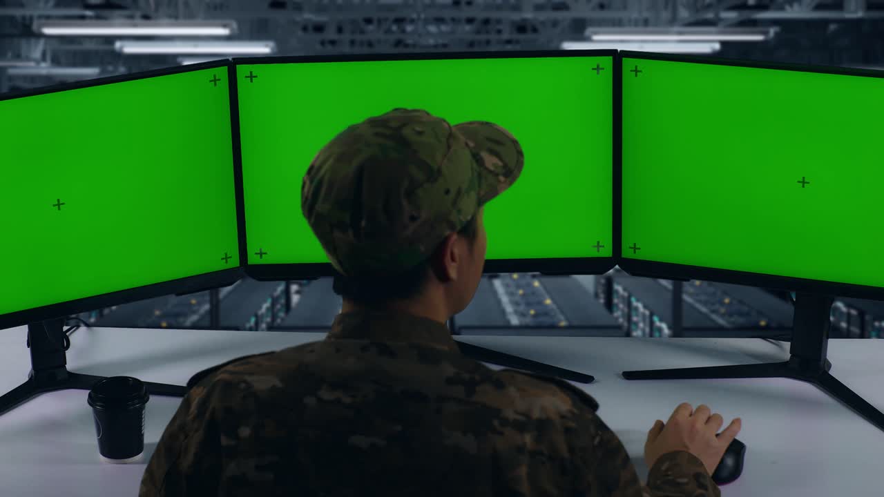 vista trasera de feliz ejército asiático celebrando y bailando mientras trabajaba con simulacro de múltiples monitores de computadora en el centro de datos