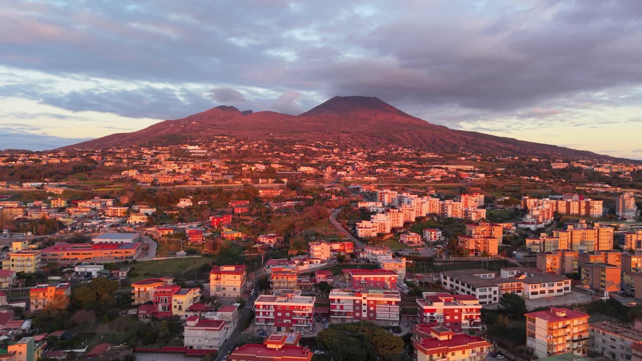 Filmato aereo del Vesuvio al tramonto, che cattura il vulcano in tutta la sua imponenza, il paesaggio circostante e la calda luce dorata. Vista aerea che mette in risalto l'iconico punto di riferimento italiano.