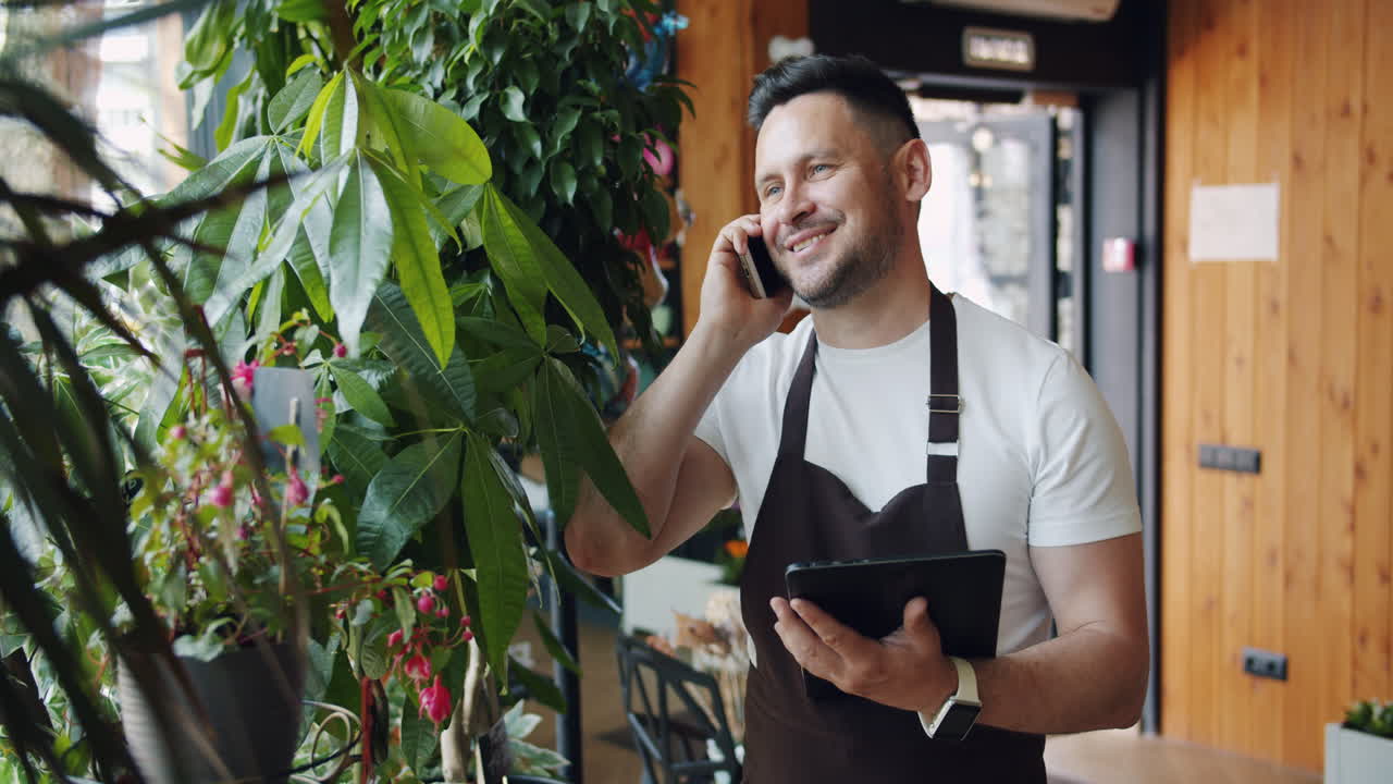 Fiorista che parla al telefono e usa il tablet