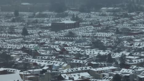 Drone-zoom-shot-showing-snow-covered-housing-area-in-USA-in-winter