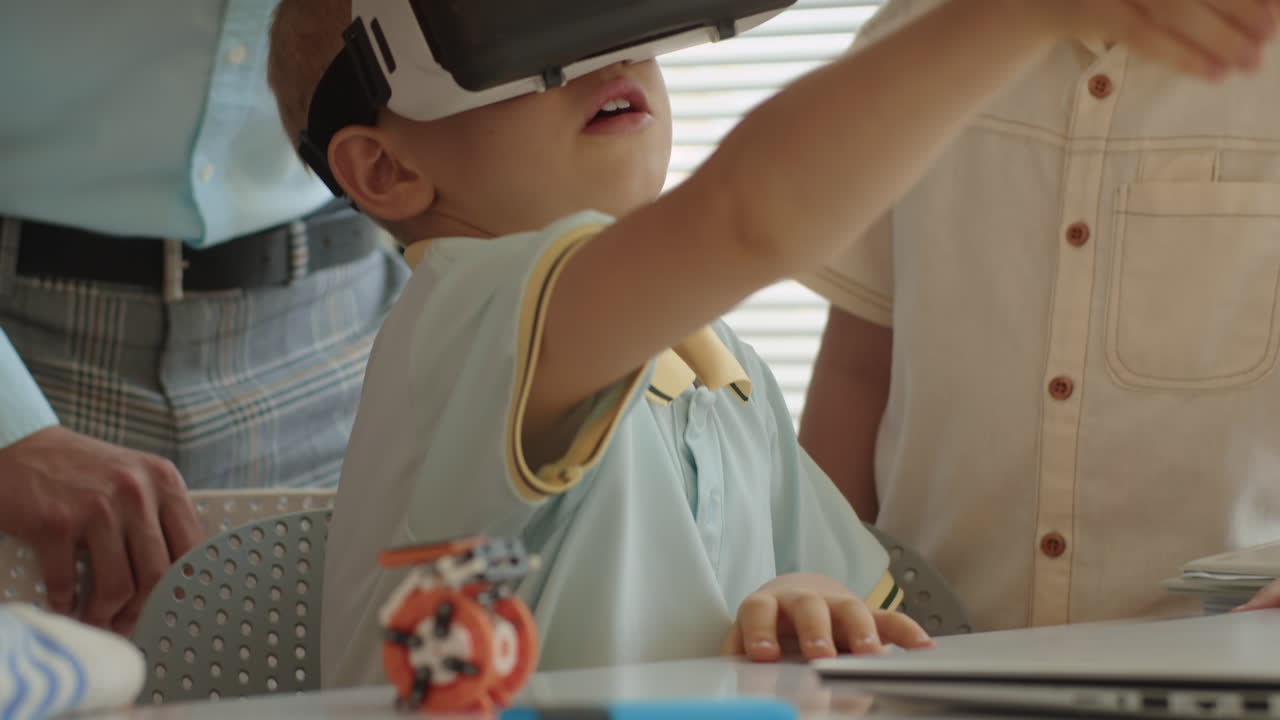 Children Looking at Their Friend Playing VR Glasses during It Lesson