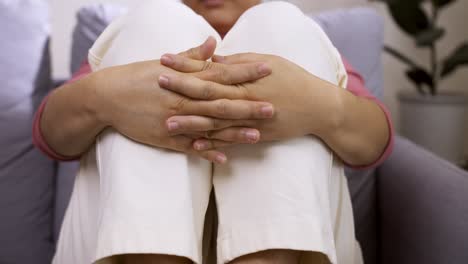 nervous young woman hugging her legs, feeling insecure