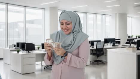 happy muslim businesswoman counting money