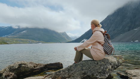 Eine-Frau-Schaut-Sich-Einen-Hochgelegenen-See-In-Norwegen-Abgelegen-An-Und-Rennt-Vor-Dem-Ganzen-Konzept-Davon-4k-Vid
