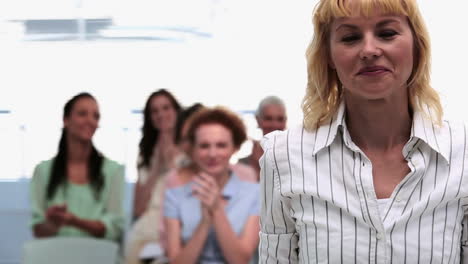 businesswomen applauding colleague after presentation