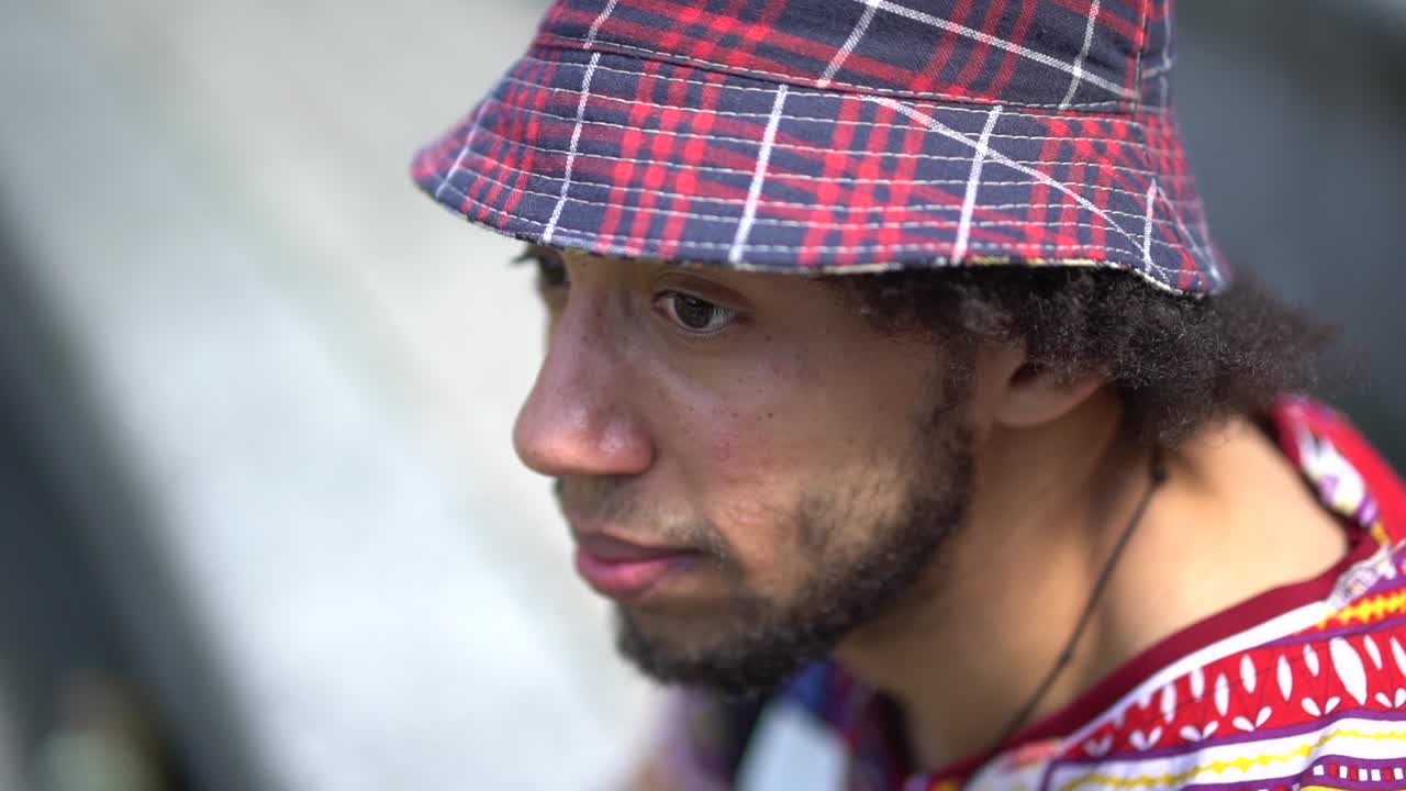 An ethnic young man looking around while dressed in urban street clothing.