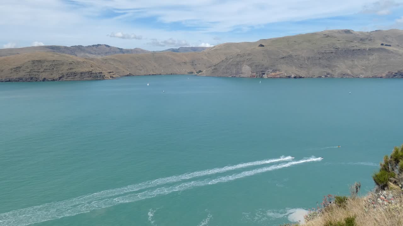 motos de agua aceleran una al lado de la otra en el océano turquesa hacia el puerto - península de banks, nueva zelanda