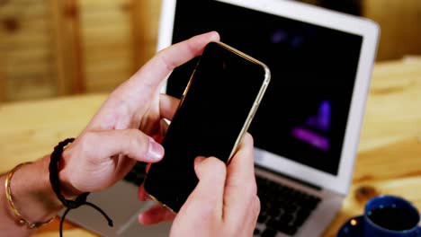 Male-customer-using-mobile-phone-at-counter