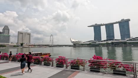 pedestrians walking along a scenic waterfront promenade.