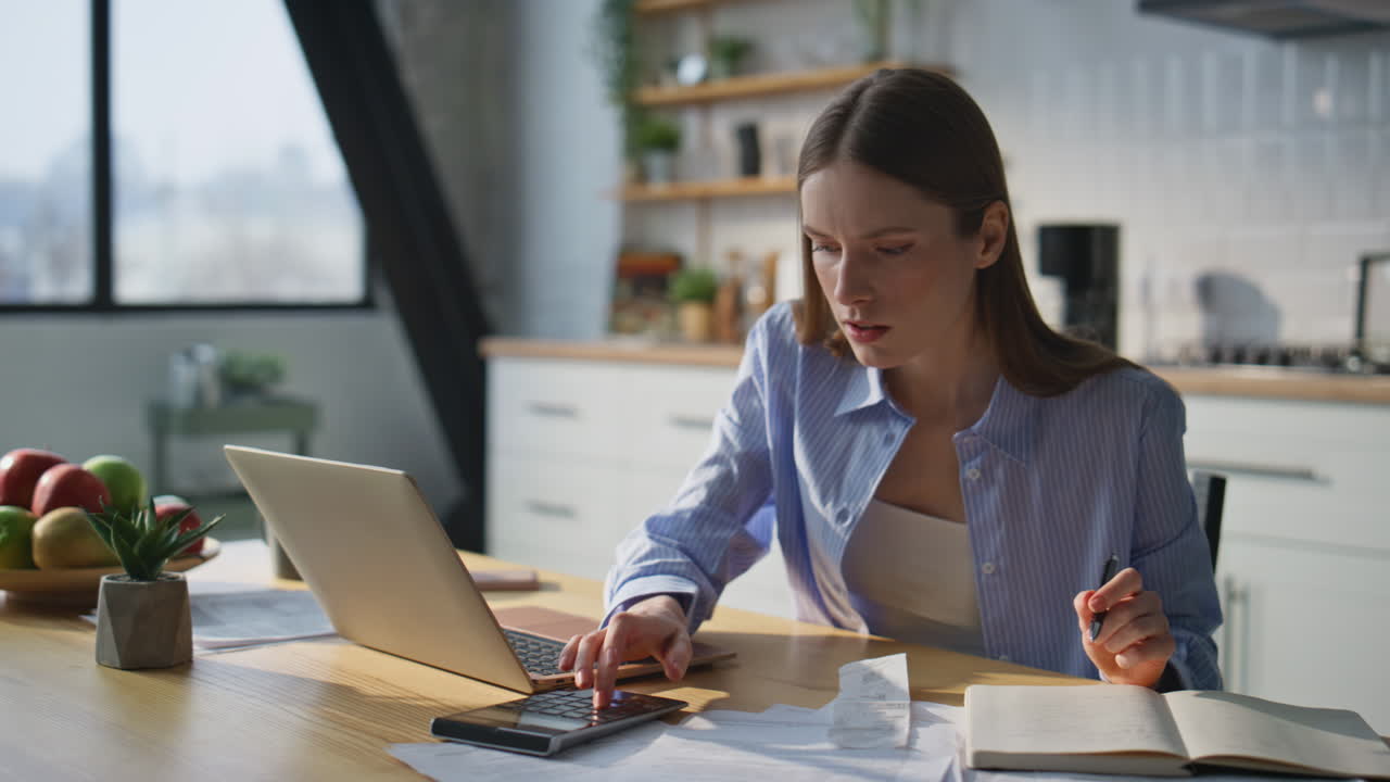 Pensive entrepreneur planning budget at home work desk with laptop closeup
