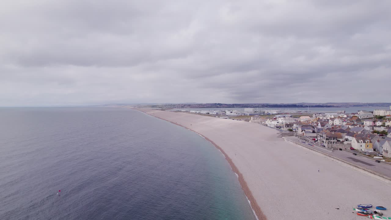 drone skudt flyver fremad langs chesil beach på en solrig dag, weymouth, dorset, storbritannien