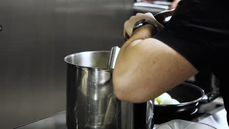 slow motion detail of chef grinding fresh black pepper in professional kitchen