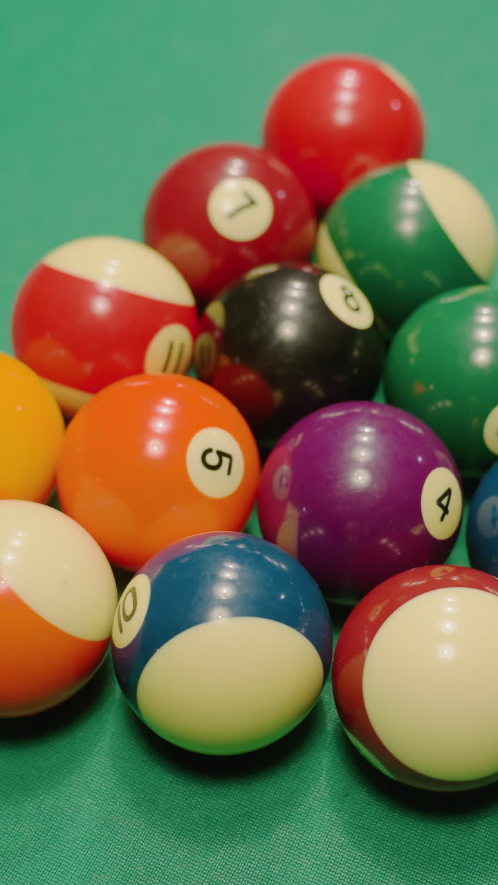 las bolas de billar explotan desde la formación triangular en la mesa de billar verde después de un poderoso tiro de ruptura, rodando en múltiples direcciones con un fuerte impacto, creando movimiento dinámico y acción de ritmo rápido