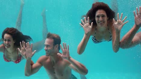 grupo de amigos nadando bajo el agua