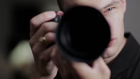 fotógrafo masculino levanta la cámara para capturar un hermoso retrato en el estudio - cerrar