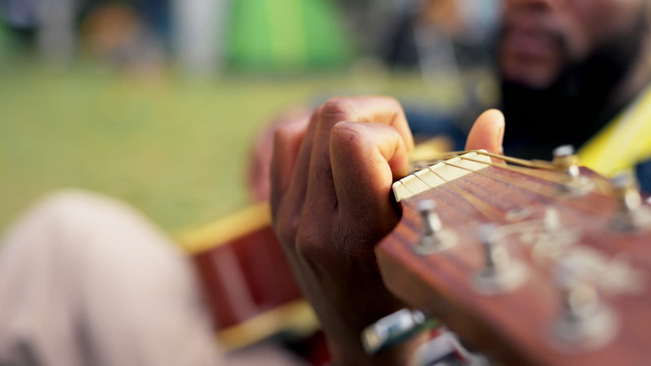 hombre, tocando la guitarra con las manos al aire libre
