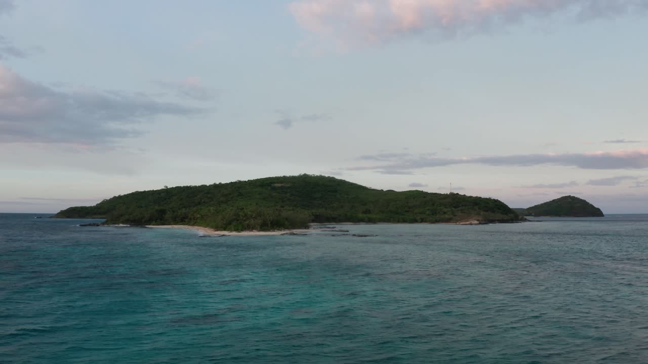 해가 지는 동안 바다 위에 정적으로 매달려 있는 드론에 의해 포착된 열대 섬의 멋진 풍경