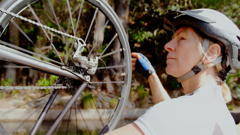 Senior-cyclist-checking-bicycle-at-countryside-4k