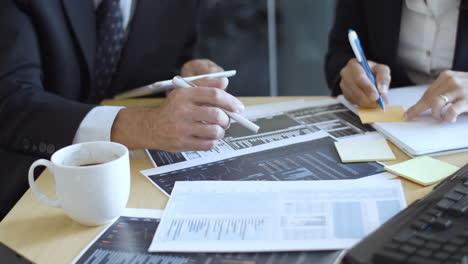 business team analyzing charts on paper reports