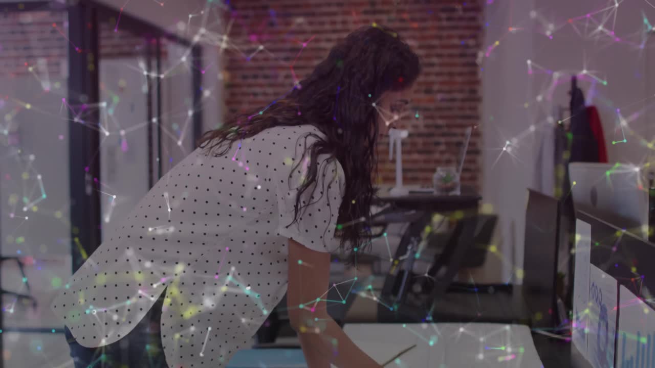 Digital composite video of network of connections against indian woman making plan design at office