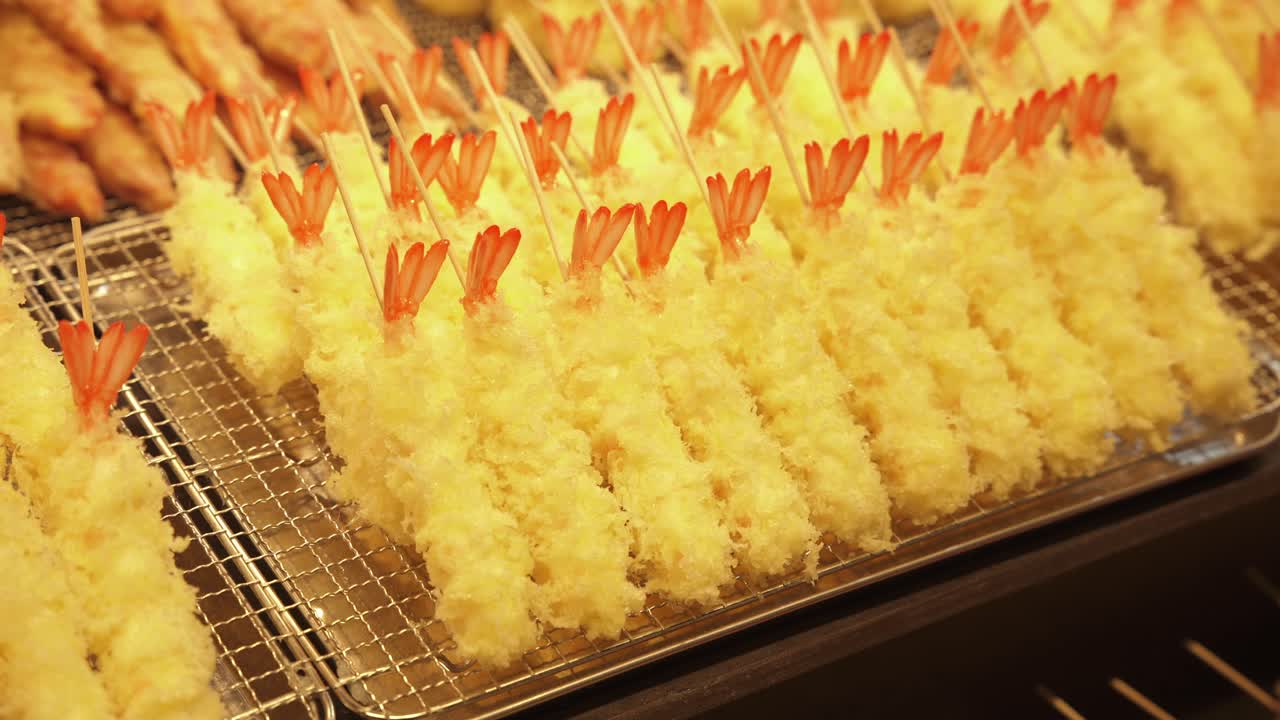키오토의 거리 음식 판매자에서 제공되는 황금색, 한 새우 템푸라의 클로즈업으로, 이 사랑받는 일본 요리의 한 질감과 섬세한 맛을 보여줍니다.