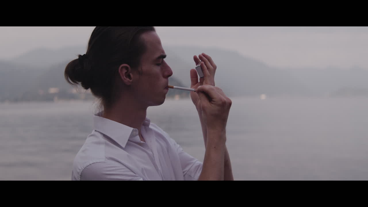 Man Smoking by the Lake
