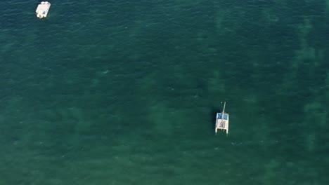 Aerial-drone-top-view-shot-of-beautiful-incredible-turquoise-clear-ocean-water-with-small-fishing-boats-near-the-tropical-Bessa-beach-in-the-coastal-capital-city-of-Joao-Pessoa,-Paraiba,-Brazil