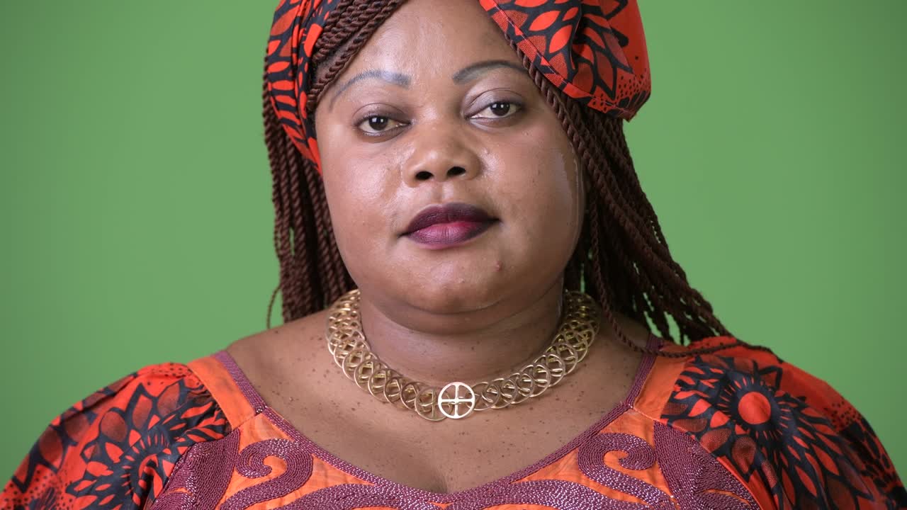 красивая африканская женщина в традиционной одежде на зеленом фоне