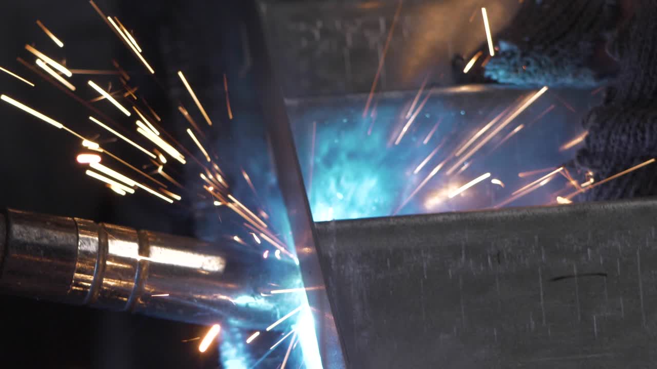 Welder works in metal construction - construction and processing of steel components