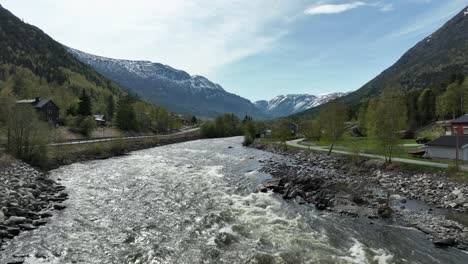 Bovra-river-in-Lom-and-Fossbergom-Norway---Aerial-above-river-while-looking-at-road-towards-Sognefjellet-mountain