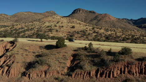 antena cinematográfica que pasa sobre un vehículo en un remoto paisaje desértico, 4k