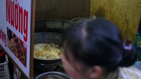 dama vietnamita cocinando comida callejera