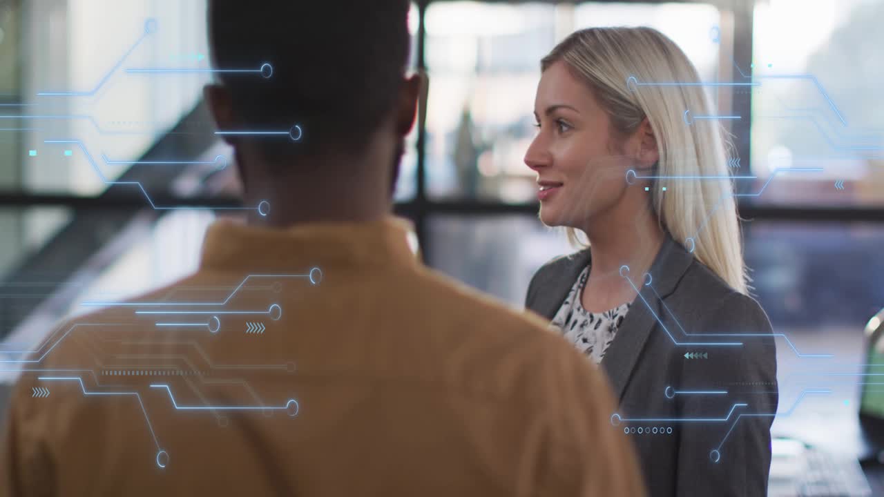Woman starting explanation to peer in office, circuit HUD appearing across frame aligning tech team