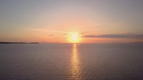 aerial view of beautiful ocean sunset in thailand - camera tracking above water