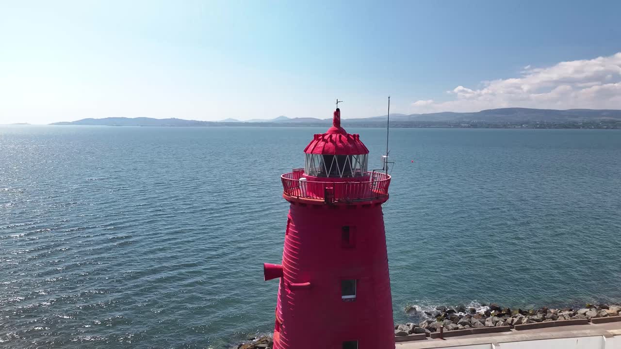Beautiful aerial close up to Poolbeg Lighthouse tower and reveal of Dublin cityscape, Ireland