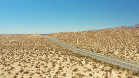 descending aerial view of midland trail's highway 14 through the mojave desert landscape