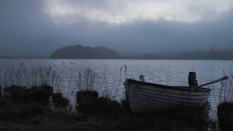 Inseluferlinie-Gestrandeter-See-Boot-Abenddämmerung-Schwäne-In-Der-Ferne