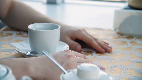 person relaxing at a cafe with coffee/tea