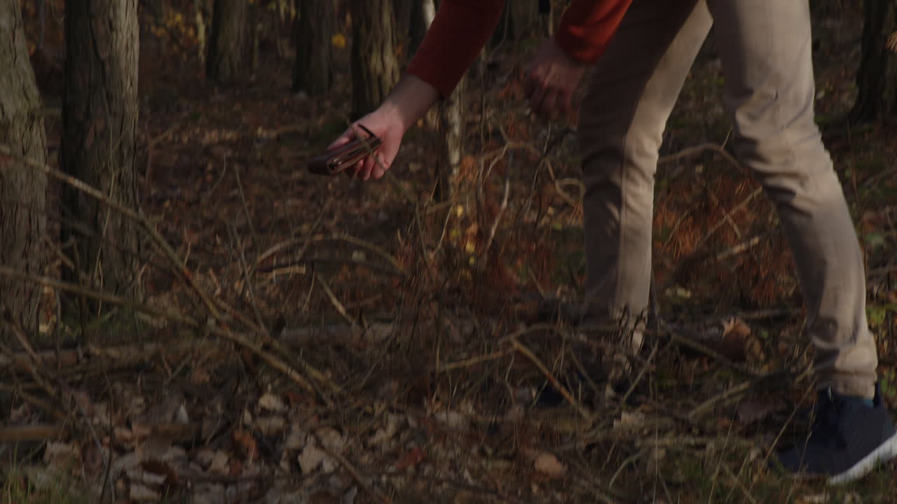 길을 걷는 관광객, 행운의 날 또는 범죄 증거물이 숲에서 잃어버린 지갑을 발견했습니다.
