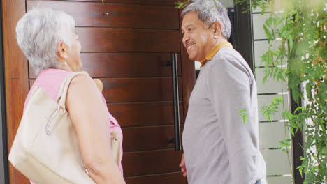 Happy-senior-diverse-couple-coming-home-with-groceries