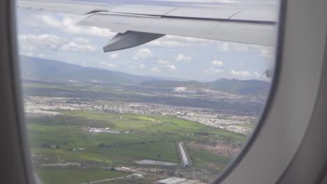 Close-Up-of-Airplane-Wing-Through-Window-During-Ascent