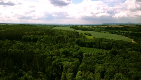 drone footage with graded skies and clouds over a green country side while descending down to ground level in beautiful germany