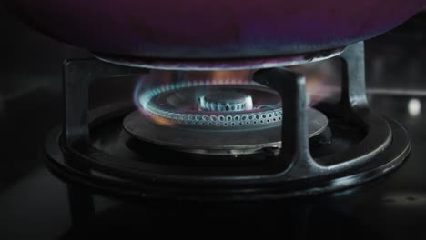 video of a black gas stove with blue and red burning flame in the kitchen