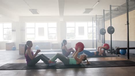 Unverändertes-Gruppentraining-Verschiedener-Frauen-Zu-Zweit-Mit-Medizinbällen-Im-Fitnessstudio,-Zeitlupe,-Kopierraum